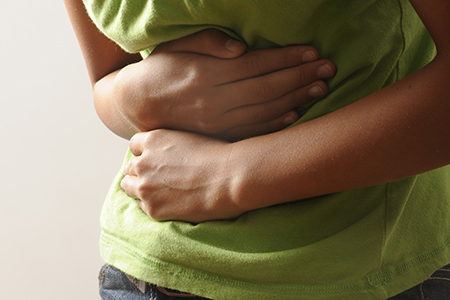 A woman clutching her stomach in pain