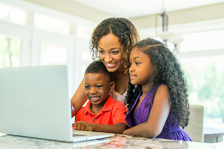 Una madre y dos niños con una laptop