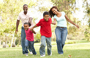 Familia corriendo feliz sobre un césped verde