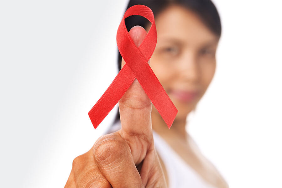 Woman holding red HIV/AIDS awareness ribbon